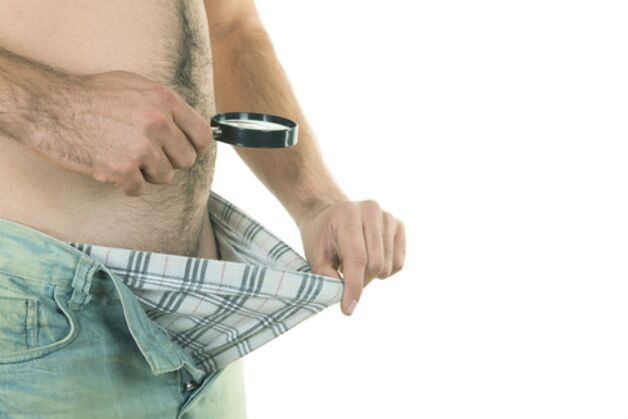 muž sa pozerá na svoj penis a chce ho zväčšiť